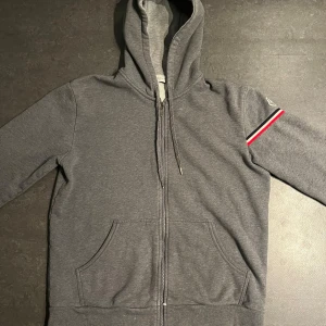 Moncler zip hoodie - Moncler zip hoodie grå, finns tecken på slitage men annars bra skick. Storlek L men passar M. 