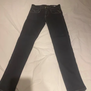 Mörkblå Replay Anbass jeans - Säljer ett par mörkblå Replay Anbass jeans. Jeansen har skinny passform och är tillverkade i ett stretchigt denimtyg som sitter skönt hela dagen. Buda gärna! FÖRST TILL KVARN!