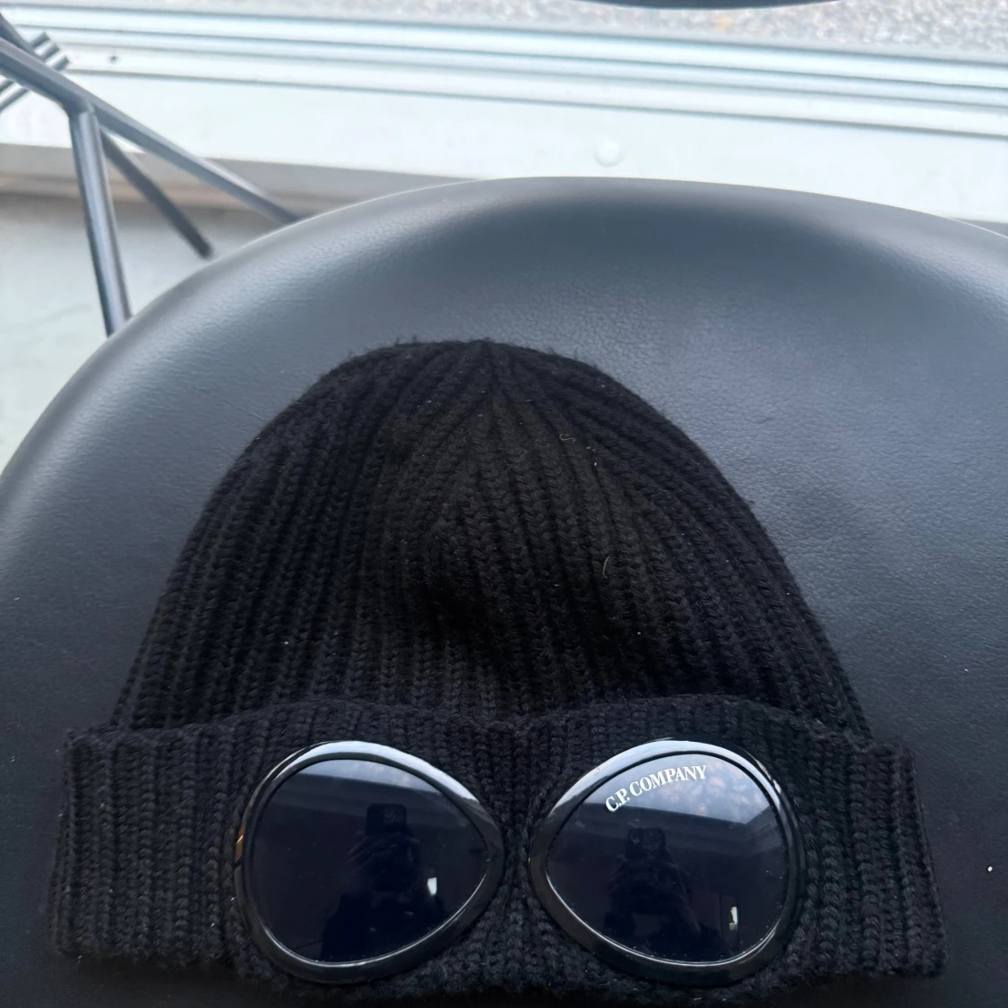 Svart ribbstickad mössa med glasögondetalj från C.P. Company