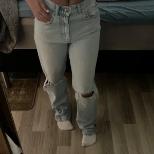 Ljusblå jeans från g perfect jeans - Säljer ett par ljusblå jeans från g perfect jeans. De har raka ben, hög midja och slitningar vid knäna för en cool look. Klassisk femficksmodell med knapp och dragkedja framtill.