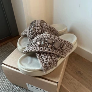 Beige sandaler med stickad ovandel och pärldetaljer - Säljer ett par beige sandaler från Inuikii dekorerad med pärlor och stenar. Bra skick endast undersidan av sulan som är smutsig då de kom till användning förra året.  Köpt för 2600kr