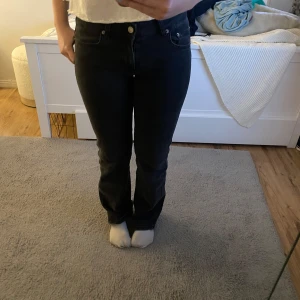 Svarta jeansbyxor med raka ben - Säljer ett par svarta jeansbyxor med klassisk femficksdesign och raka ben. Byxorna har normal passform och stängs med dragkedja och knapp. Perfekta till vardags och enkla att matcha med olika toppar.