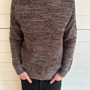 Brunmelerad stickad tröja från Brave Soul - Säljer en brunmelerad stickad tröja från Brave Soul. Tröjan har lång ärm och är gjord i ett grovt stickat material med inslag av vitt och svart. Perfekt för kyligare dagar och har en klassisk rund halsringning. Helt ny med lapp!