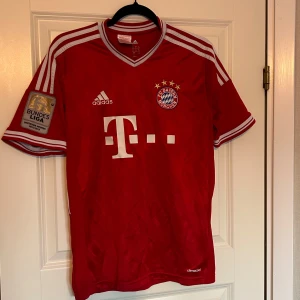 Bayern München Ribéry 7 (2012/13) Äkta - Original Bayern München-matchtröja från 2012/13 säsongen med Ribéry 7 på ryggen. Broderad Adidas-logga & klubbmärke på bröstet och Bundesliga- Deutsche Meister märke på ärmen. Tillverkad i lätt climacool-material för bra ventilation. (Passar som storlek S)