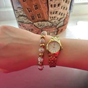 Armband med guld- och silverfärgade pärlor - Säljer ett snyggt armband med växelvis guld- och silverfärgade pärlor. De silvriga pärlorna har glittrig yta och de guldfärgade är blanka. Perfekt accessoar för att lyfta din outfit. Armbandet är stretchigt så det passar alla!😍🥰Aldrig använt förutom på bilden💕