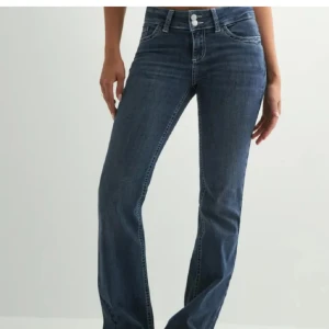 Blå bootcut jeans med broderade fickor - Något slitna längst ned 