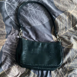 Svart axelväska  från Gina Tricot - Svart axelväska från Gina Tricot med krokodilmönster