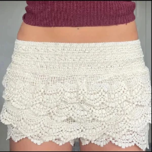 Beige spetsshorts med volanger - Superfina beige virkade shorts med flera lager volanger. De har en elastisk midja och är perfekta för varma dagar. Postar inom 24 timmar!