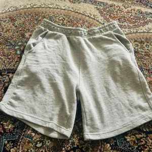 Grå mjuka shorts Pull&Bear S - Gråa shorts från Pull&Bear i mjuk bomull med elastisk midja och snörning. De har två sidofickor och en bakficka, perfekt för chill dagar. Klassisk loose fit och enkel stil som funkar till allt under sommaren.