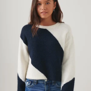 Svartvit stickad tröja från Gina Tricot - Säljer en stickad tröja från Gina Tricot i svart och vitt. Tröjan har ett coolt asymmetriskt mönster och långa ärmar. Perfekt till jeans eller kjol för en avslappnad stil. Säljer för den inte kommer till användning. Väldigt bra skick använd fåtal gånger💗