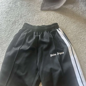 Palm Angels svarta trackpants med vit stripe - Ett par fina svarta palm angeles shorts i bra tillstånd. Knappt använda och fin kvalité. OBS! Pris kan diskuteras vid snabbt köp!