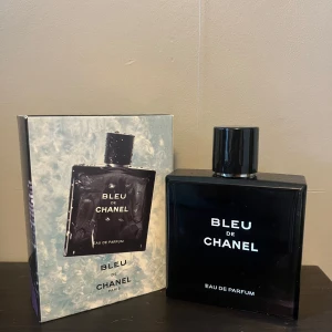 Bleu de Chanel Eau de Parfum - Bleu de Chanel Eau de Parfum är en ikonisk herrdoft i en elegant, mörkblå glasflaska med svart lock och tydlig Chanel-logga på toppen. Flaskan är fyrkantig och stilren, och parfymen levereras med originalkartong. En klassisk och maskulin doft från Chanel. Cirka 45/100ml kvar, du får med ett Hugo boss sampel med.
