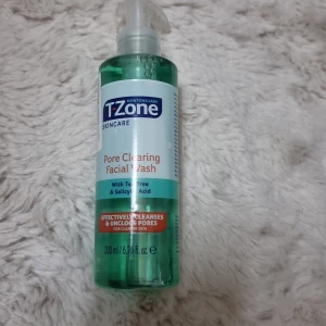 T-Zone Pore Clearing Facial Wash - T-Zone Pore Clearing Facial Wash med tea tree och salicylsyra. Kommer i en genomskinlig grön plastflaska med pump, 200 ml. Perfekt för dig som vill rengöra huden på djupet och få bort tilltäppta porer. Helt ny och oanvänd.