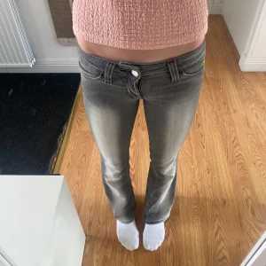 Grå bootcut jeans från Cheap Monday - Storlek 24/32                                   Säljer ett par gråa lågmidjade jeans från Cheap Monday med snyggt slitna detaljer och bootcut-ben. Den gröna loggan på baksidan har släppt lite, så man kan antingen ta bort den eller sy fast den lite💕💕