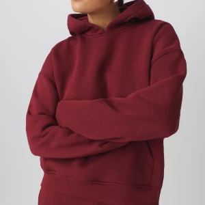 Vinröd hoodie  - Snygg vinröd hoodie med huva och magficka. Tröjan har en relaxed passform och är tillverkad i mjuk bomullsmix. Perfekt för dig som gillar en enkel och stilren look med streetkänsla. Långärmad modell med ribbade muddar.
