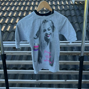 Grå sweatshirt med tryck från Lindex - Grå sweatshirt från Lindex med coolt svartvitt tryck framtill och texten 'Pump this volume!' i rosa. Tröjan har korta ärmar och ribbade muddar vid hals och ärmslut. Perfekt för dig som gillar streetstyle och bekväma plagg.
