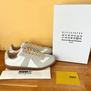 Maison Margiela gats (NYA) - Säljer ett par ikoniska Maison Margiela GAT i klassisk vit färg – en tidlös siluett med lyxig känsla. Helt nya, storlek 42. Vid andra funderingar är det bara att hojta till. 0bs;lnte 0rglnal 