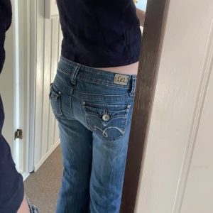 Jättesnygga jeans - As snygga lågmidjade bootcut jeans med coola fickor med knapp. De är köpta i Paris och har aldrig använts då det ej passar. För övrigt i väldigt fint skick utan slitningar, storlek XS/S💓Hör av er vid funderingar 💕