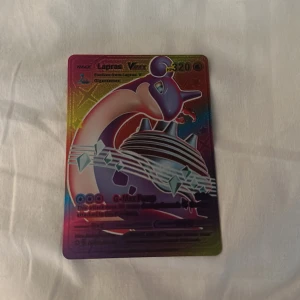 Lapras VMAX - En färgstark och glittrande Pokémon-samlarbok med Lapras VMAX på omslaget. Perfekt för dig som älskar Pokémon och vill ha något unikt i din samling. Boken har en cool design som sticker ut och passar både unga och unga vuxna.