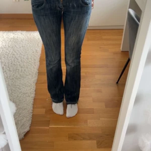 Blå bootcut jeans från Lee - Säljer ett par snygga blå jeans från Lee med bootcut passform. De är väldigt lågmidjade, de är i storlek W26 och L 33. Men har sprättat sömnen längst ner så de är lite längre, hon på bilden är 170. De har hål längst ner på baksidan som man ser på bilden. Pris kan diskuteras💕