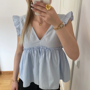 Ljusblå topp - Säljer denna söta ljusblåa topp från Zara. Den är använd vid något tillfälle men är i mycket bra skick. Den går även att knyta där bak💕