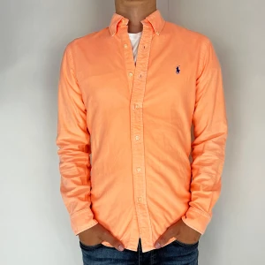 Ralph Lauren Skjorta - Nu har vi nöjet att erbjuda en klassisk  skjorta från det välkända varumärket Ralph Lauren. Plagget är i storlek Small och är i mycket gott skick, utan några synliga defekter. Modellen på bilden är 182 cm lång och väger 75 kg, vilket kan ge en god indikation på tröjans passform.