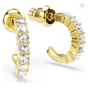 Swarovski örhängen med kristaller - Säljer ett par snygga örhängen från Swarovski. De är halvcirkelformade och prydda med gnistrande, runda Swarovski-kristaller längs hela framsidan. Perfekta för dig som gillar bling och vill sticka ut med stilrena detaljer.