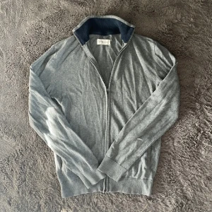 Grå cardigan från Pier One - Säljer en fet cardigan från Pier One i grå färg. Passformen är perfekt. Skick 9/10. Använd fåtal gånger. Hör gärna av er om ni har några funderingar!