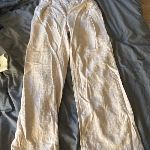 Beiga linnebyxor från Marilux - Snygga och luftiga beiga linnebyxor från Marilux. Byxorna har raka ben, resår i midjan och hällor för bälte. Perfekta för varma dagar när du vill ha en chill och stilren look.