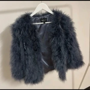 Mörkgrå fluffig pälsjacka från NC - Supermjuk och fluffig mörkgrå pälsväst från NC. Västen har en lyxig känsla med långhårig päls och silkeslen insida. Perfekt att slänga över en topp för en cool och trendig look. Rak passform och öppen framtill. Nypris: 7 429kr.  Äkta pälsjacka. Säljer billigt för vill bli av med den då jag inte använder den. 