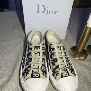 Dior skor - Super snygga Walk'n'Dior Sneakers från dior i storlek 38 och i super gott skick! Köpt av en tjej på plick för  5000 kr, tyvärr är dessa för små för mig eftersom jag egentligen har 38,5 i storlek :) Har ingen aning om äkthet eftersom inget kvitto medföljde, därav det låga priset. Box medföljer!
