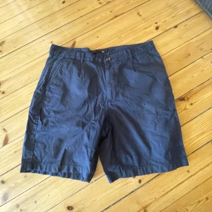 Mörkblå shorts från 157 - Snygga mörkblå shorts från 157 i en skön mix av linne och bomull. De har en klassisk design med knapp och dragkedja framtill. Perfekta för en avslappnad stil.