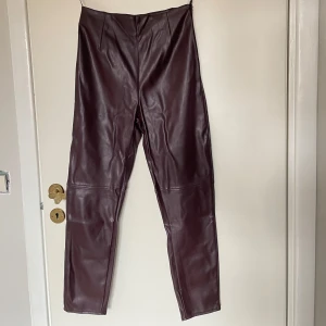 Vinröda skinnbyxor petite  - Vinröda/bruna skinnbyxor från Missguided i petite-modell storlek EU34. Byxorna har en medelhög midja och tight passform. De har en dragkedja i sidan för enkel på- och avtagning. 