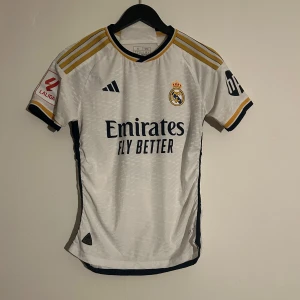 Real Madrid tröja - Säljer en vit Real Madrid, det var dumt av mig att köpa i S då den har blivit för liten och behöver nu säljas. Använt den max 3 gånger och den är utav mycket hög kvalité.