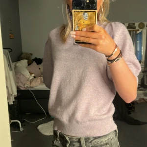 Ljuslila tröja från Vero Moda - Säljer en ljuslila tröja från Vero Moda. Tröjan har en mjuk och bekväm passform med korta puffärmar och ribbade kanter. Perfekt för en stilren och avslappnad look.