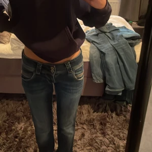 Blå jeans från Pepe Jeans - Snygga blå jeans från Pepe Jeans med låg midja och bootcut. De har en klassisk femficksdesign och dubbla knappar i midjan. Perfekta för en stilren look. Köpta för 1100 