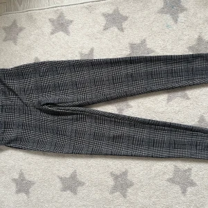 Rutig byxa från Shein - Snygga svartvita rutiga byxor från Shein i storlek XS. Byxorna har en tight passform och är perfekta för en stilren look. Tillverkade i ett mjukt och bekvämt material.