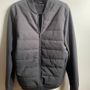 Grå Cardigan från Massimo Dutti - Snygg grå Cardigan från Massimo Dutti med dragkedja framtill. Jackan har en quiltad design och långa ärmar. Perfekt för en stilren look. Perfekt för våren☀️