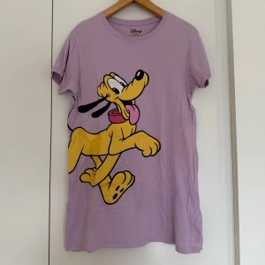Nattlinne - Säljer detta supersöta ljuslila nattlinne med Pluto på 💕💜 lite skrynklig på galgen men annars är enda defekten att trycket har en spricka i sig (se sista bilden).