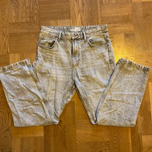 Gråa baggy jeans från Bershka - Säljer ett par baggy jeans från Bershka i en ljusblå/grå tvätt. De har en avslappnad passform med fem fickor och nitar i kopparfärg. Perfekta för en casual look! Det finns inga slitningar så de ser typ helt nya ut. Om du har någon fråga är det bara att skriva. 🩶