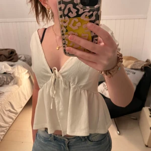 Vit blus med knytning - Säljer en söt vit blus med knytning framtill. Inga defekter eller fläckar. Perfekt för sommaren. 