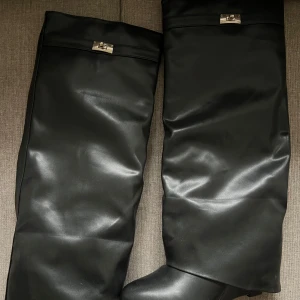 Svarta stövlar i skinn - Snygga svarta stövlar med stilren design. De har metallspänne upptill som ger en elegant touch. Perfekta för höst och vinter, dessa stövlar är både praktiska och trendiga. Köpte dessa här på Plick men det var för små för mig. Det finns några vita fläckar på dem, fick dem så. Men inget man tänker på. Storlek 41🩷