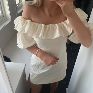 Kräm vit klänning  - Jätte söt klänning från hm i en krämig vit färg som man båda kan ha off shoulder och på axlarna🥰 den är inte så kort som på bilderna, jag bara har vikt upp den. 