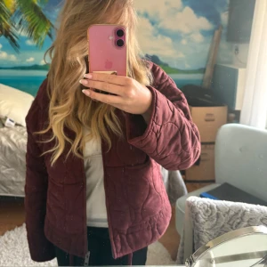 Vinröd jacka från Zara - Säljer en snygg vinröd vadderad jacka från Zara. Jackan har en dragkedja framtill och två praktiska fickor. Perfekt nu till våren! Väldigt ny och endast använd någon enstaka gång! 🥰