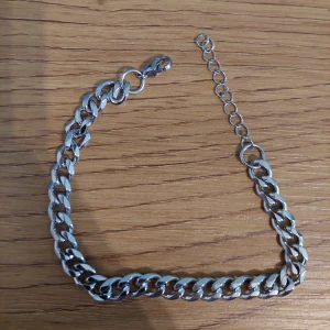 Silverfärgat armband - Snyggt silverfärgat armband med breda länkar som ger en stilren och modern look. Perfekt för att komplettera din outfit med en touch av elegans.