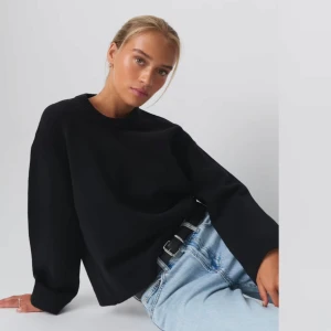 Svart stickad tröja - Säljer en stilren svart stickad tröja med rund hals och långa ärmar. Perfekt för en avslappnad look. Passar bra till jeans eller kjol. Aldrig använd