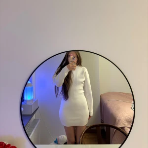 Vit långärmad klänning - Säljer en stilren vit klänning med lång ärm och tight passform. Perfekt för en elegant look. Klänningen är enkel men ändå chic, vilket gör den lätt att styla med olika accessoarer.