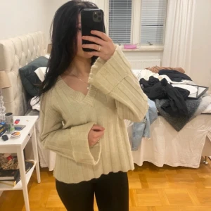 Beige ribbad tröja med v-ringning - Säljer en mysig beige tröja med v-ringning och långa ärmar. Tröjan har en ribbad design som ger en stilren look. Perfekt för kyligare dagar.