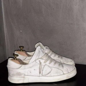 Vita sneakers från Philippe Model - Snygga vita sneakers från Philippe Model med klassisk design och snörning. Skorna har en vit ovandel och en svart sula, vilket ger en stilren kontrast. Skorna har en sliten design som är snygg och Perfekta för en avslappnad look. Nypris 3800kr. Pris kan diskuteras👍