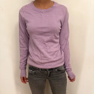 Ljuslila tröja - Säljer en ljuslila tröja med rund hals och långa ärmar. . Tröjan har en mjuk och bekväm passform. Aldrig använd 